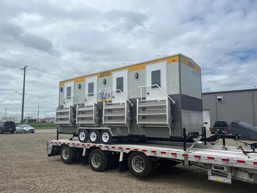 Worker walking past a job site portable toilets unit.